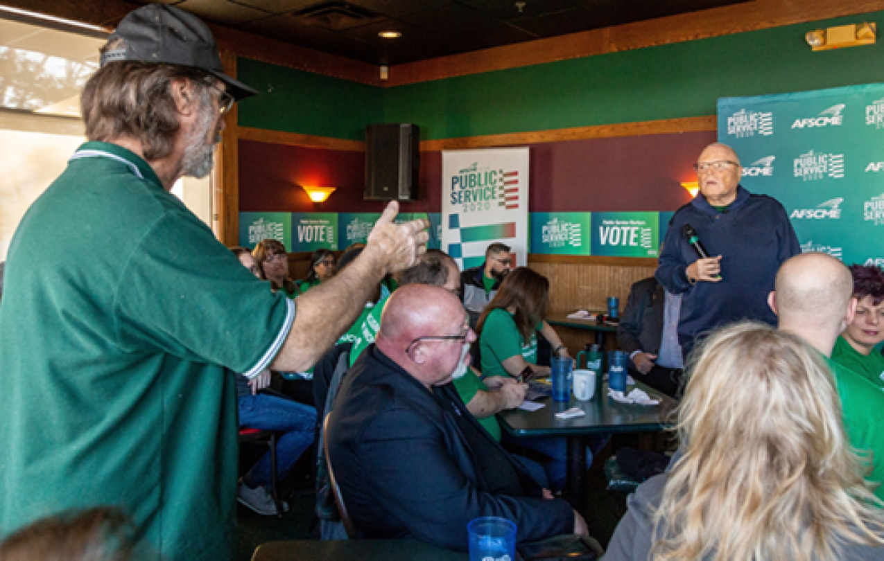 Lee Saunders speaks with an AFSCME member at an event before the Iowa caucus
